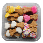 Assorted dog treats in the shape of bones with different toppings in a clear container.