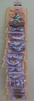 Set of hair clips in clear packaging on a wooden board against a light background